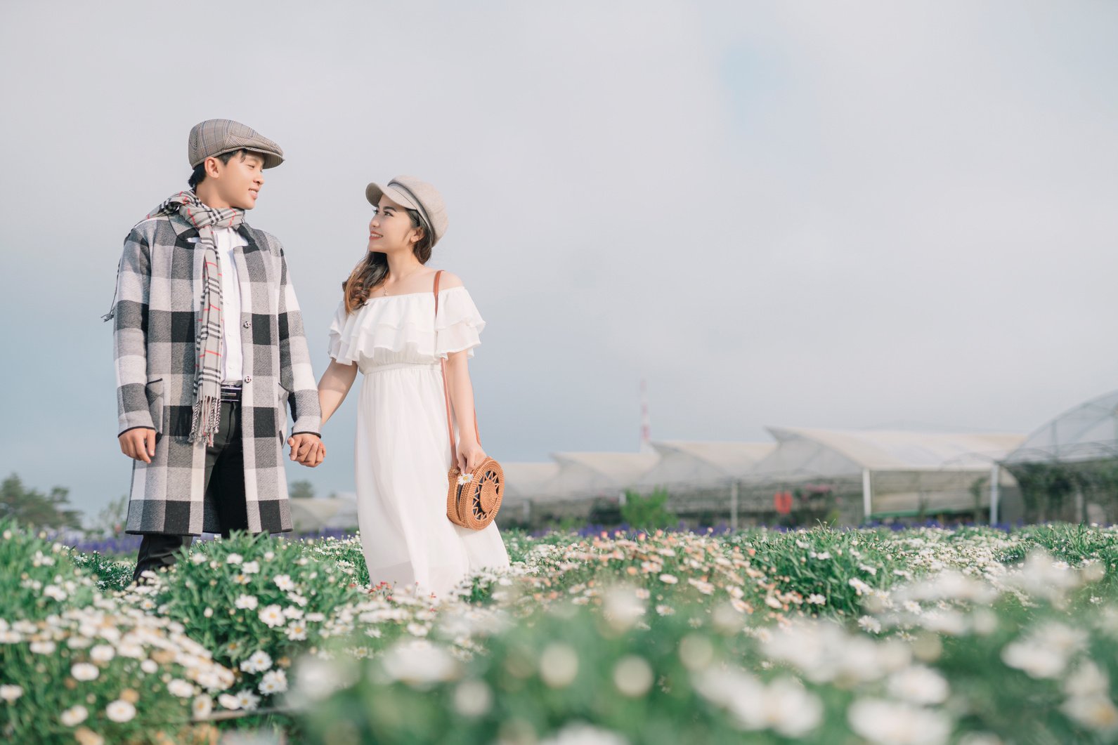 A Couple Holding Hands on a Grass Field